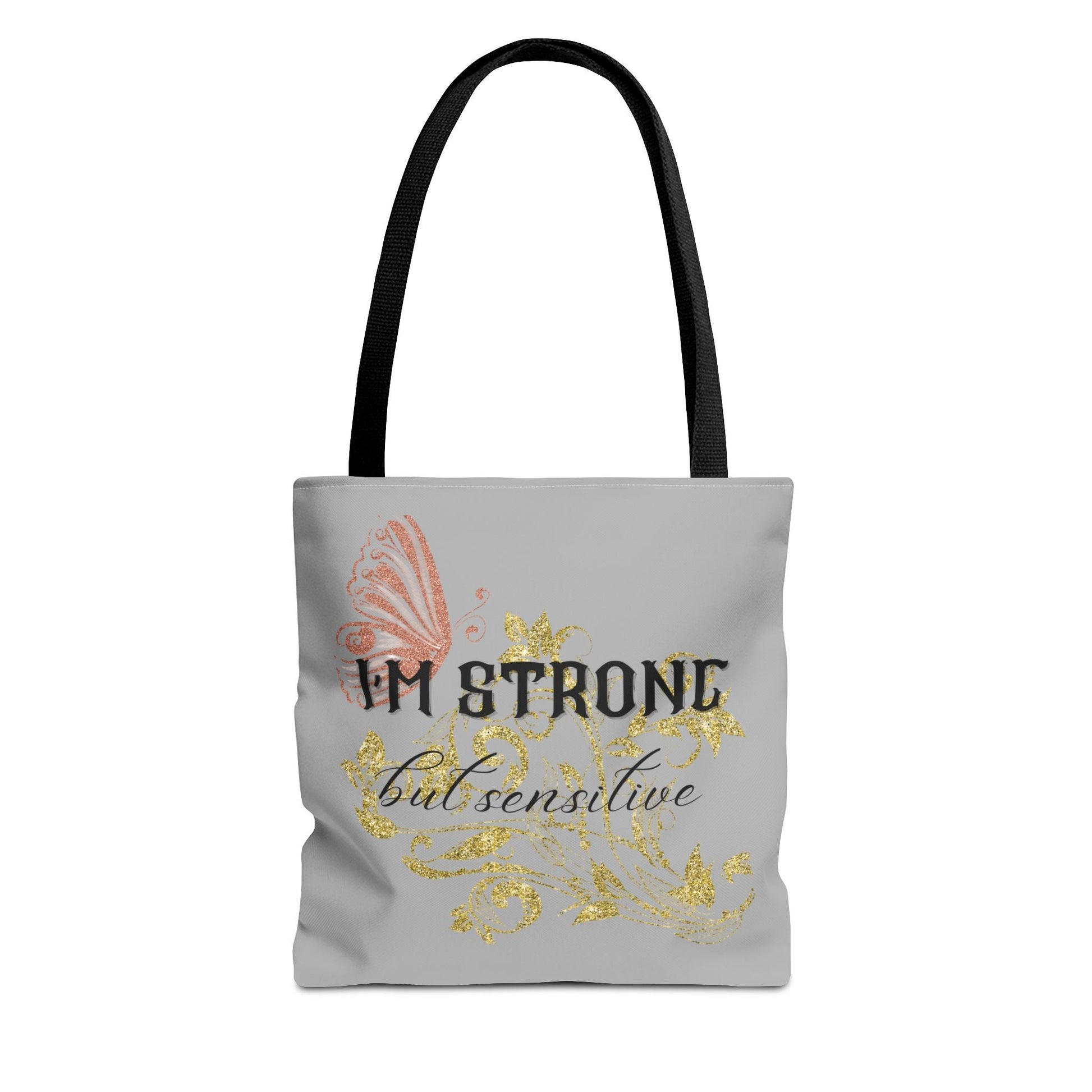 Strong but Sensitive Tote Bag with pink butterfly and gold glitter design on gray background and black handles